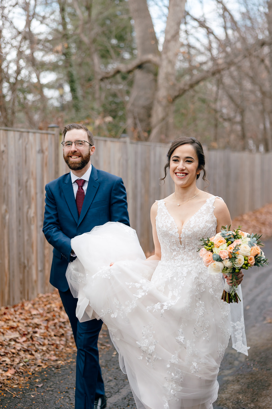 wedding couple with groom holding bride's dress walking through great falls grange
