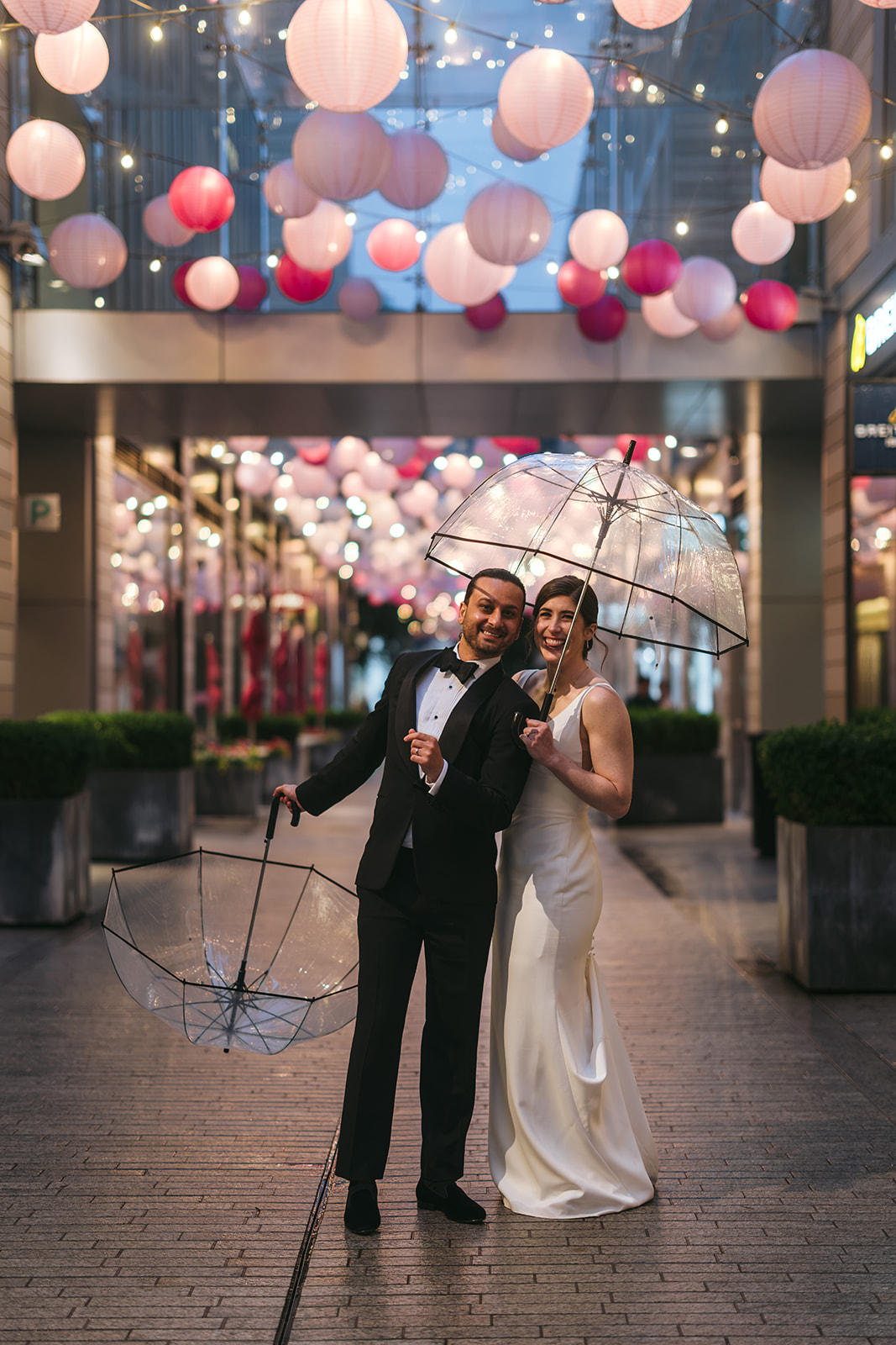 Couple posing with umbrellas after getting married in city center dc