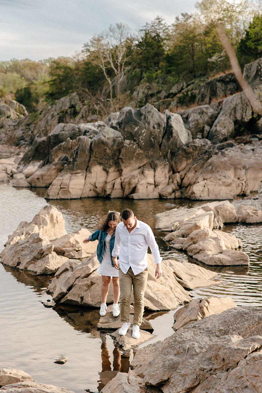 couple walking through rocks great falls park maryland